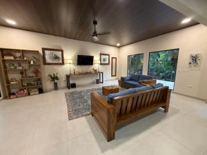a living room with a blue couch and a tv at Sal y Sol in Quepos