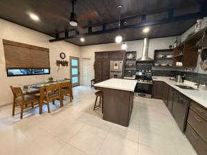 a large kitchen with a table and chairs in it at Sal y Sol in Quepos +9 photos