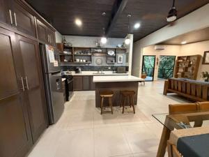 a large kitchen with a counter and stools in it at Sal y Sol in Quepos
