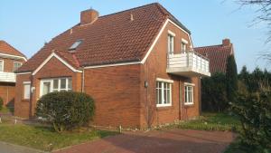 a red brick house with a balcony on it at Ditzumerhuuske in Ditzum