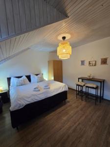 a bedroom with a bed and a table and a chandelier at LS Apartments Štefanová in Terchová