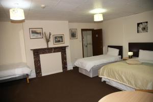 um quarto de hotel com duas camas e uma lareira em A Gosport Inn em Gosport