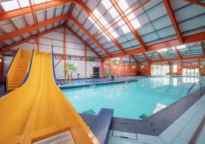 a large indoor swimming pool with a large ceiling at Seaside Escape at St Osyth in Clacton-on-Sea