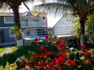a house with a swimming pool and palm trees at Casa condomínio clube in Araruama