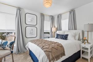 a bedroom with a bed and a chair and windows at Cottages at Oak Park in Ocean Springs