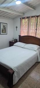 a bedroom with a large bed with a cross on the wall at Cabaña Las Lajas la pintada in La Pintada +9 photos