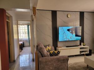 a living room with a television and a couch at Greatwall Apartment in Syokimau +9 photos