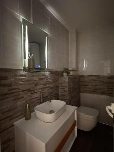 a bathroom with a sink and a toilet and a mirror at Casa Di Pafcho - Balchik Villa Retreat in Balchik