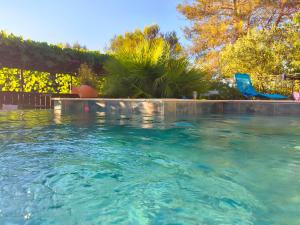 a swimming pool with a blue chair in a yard at Etage privatif chez Corinne in Russan