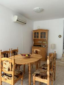 a dining room with a wooden table and chairs at Casa Di Pafcho - Balchik Villa Retreat in Balchik +8 photos