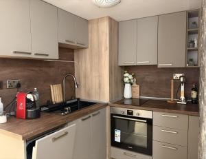 a kitchen with white cabinets and a sink at Casa Di Pafcho - Balchik Villa Retreat in Balchik