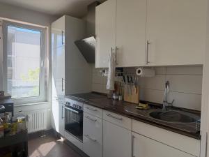 a kitchen with white cabinets and a sink and a window at Ori's apartment in Frankfurt