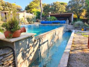 a pool in a backyard with a retaining wall at Etage privatif chez Corinne in Russan