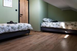 a bedroom with two beds and a wooden floor at L'aparté in Rochefort