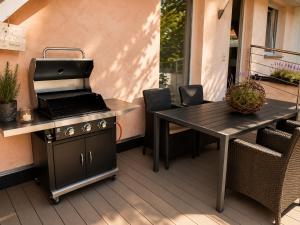 a grill and a table with a laptop on a patio at Lifestyle in Kurort Steinbach-Hallenberg