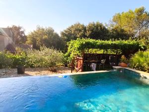 a swimming pool in a yard with a pergola at Etage privatif chez Corinne in Russan