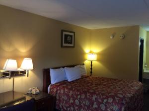 Habitación de hotel con 1 cama y 2 lámparas en Days Inn by Wyndham York Alabama, en York