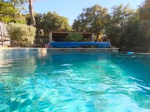 a swimming pool with blue water in a yard at Etage privatif chez Corinne in Russan