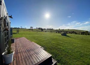 a deck with a view of a large green field at The Milkmans Shack in Dunorlan +16 photos