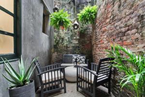 a patio with two benches and a brick wall at Luxe 8BR CBD Duplex Private Courtyard in New Orleans