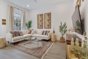 a living room with a white couch and a table at Luxe 8BR CBD Duplex Private Courtyard in New Orleans +21 photos