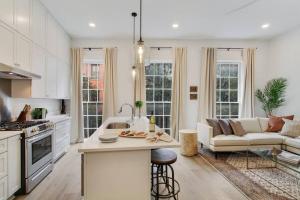 a kitchen and living room with a couch and a table at Luxe 8BR CBD Duplex Private Courtyard in New Orleans