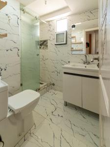 a white bathroom with a sink and a toilet at Waves Hunter Surf House in Agadir +179 photos