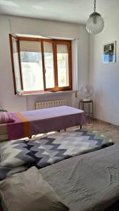 two beds in a room with a window at Casa Panorama in Senigallia