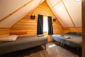 a bedroom with two beds in a log cabin at Red Salmon Retreat, Cabin 8 at Lower Kenai Lodge in Kenai