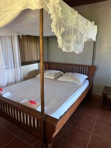 ein Bett in einem Zimmer mit Himmelbett in der Unterkunft Villa TiPunch in Nosy Be