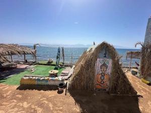 a hut with a painting on it next to the ocean at kalima camp in Nuweiba‘ el Muzeinah