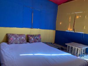 a blue room with a bed and a table at kalima camp in Nuweiba‘ el Muzeinah