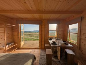 a room with a bed and a table and windows at Skyline cabin in Bugle
