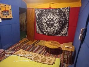 a room with a bed with a painting on the wall at kalima camp in Nuweiba‘ el Muzeinah