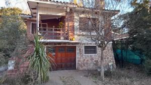 a brick house with a red door and a balcony at Rosibel in Río Ceballos