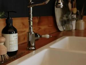 a bottle of wine sitting next to a sink at The Milkmans Shack in Dunorlan