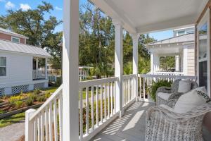 a white porch with wicker chairs on it at Cottages at Oak Park in Ocean Springs