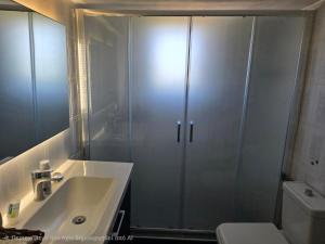 a bathroom with a shower and a sink and a toilet at Black Fig in Pollonia +25 photos