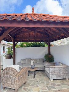 a pavilion with couches and tables on a patio at Kéra Lodge in Rivière-Pilote
