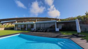 a swimming pool in front of a house at Luna Villa in Campanário