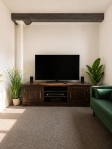 a flat screen tv on a wooden entertainment center in a living room at Comfortable Apartment set in an Old Mill in Westbury