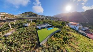 a house on a hill with a green roof at Luna Villa in Campanário