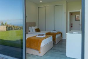 a hotel room with two beds and a balcony at Luna Villa in Campanário +40 photos