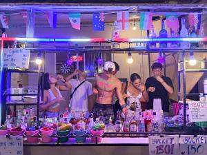 a group of people standing around a bar with drinks at JAM's HOSTEL in Ko Phangan
