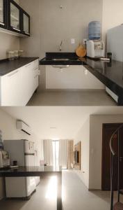 a kitchen with white cabinets and a black counter top at Atins Ville Lençóis in Atins