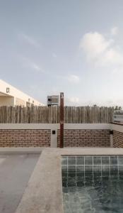 a swimming pool in front of a wooden fence at Atins Ville Lençóis in Atins