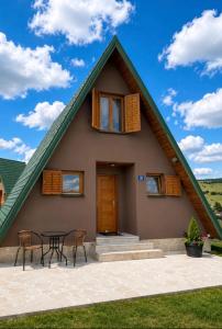 a house with a gambrel roof with a table and chairs at Holiday Home Stefani Spacious Mountain House near Durmitor 3 Bedrooms Private Parking in Žabljak