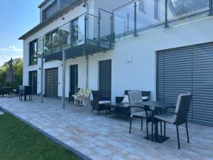 a patio with a table and chairs and a balcony at MainSpessartBlick in Lohr am Main