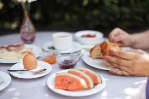 a person holding a piece of food on a table with plates of food at Garni Juval in Tirolo