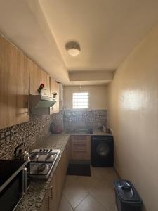 a small kitchen with a stove and a sink at Sunset Stay Anza in Agadir